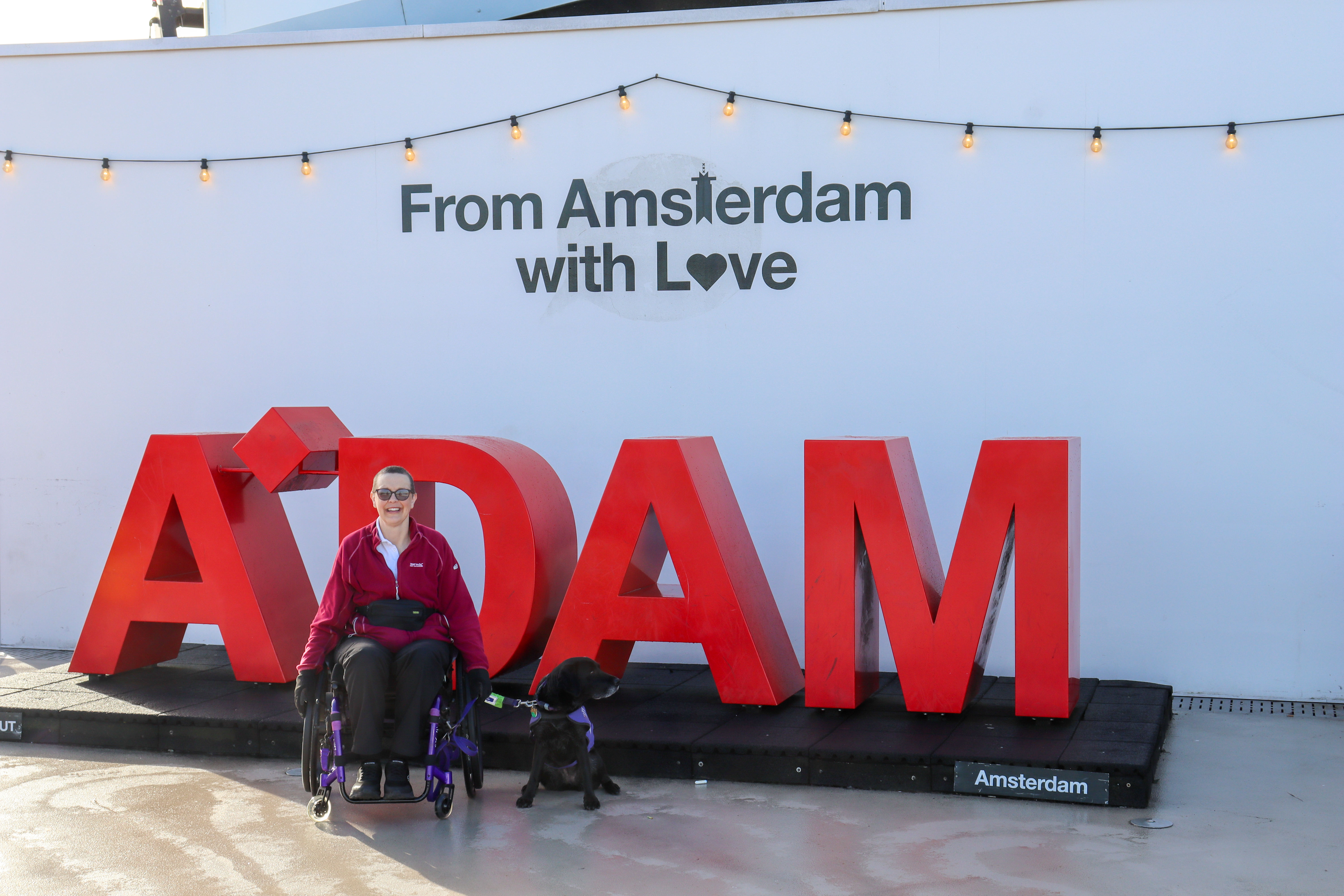 Nicki and Liggy posing in front of the A'DAM sign that has a caption, From Amsterdam with love.