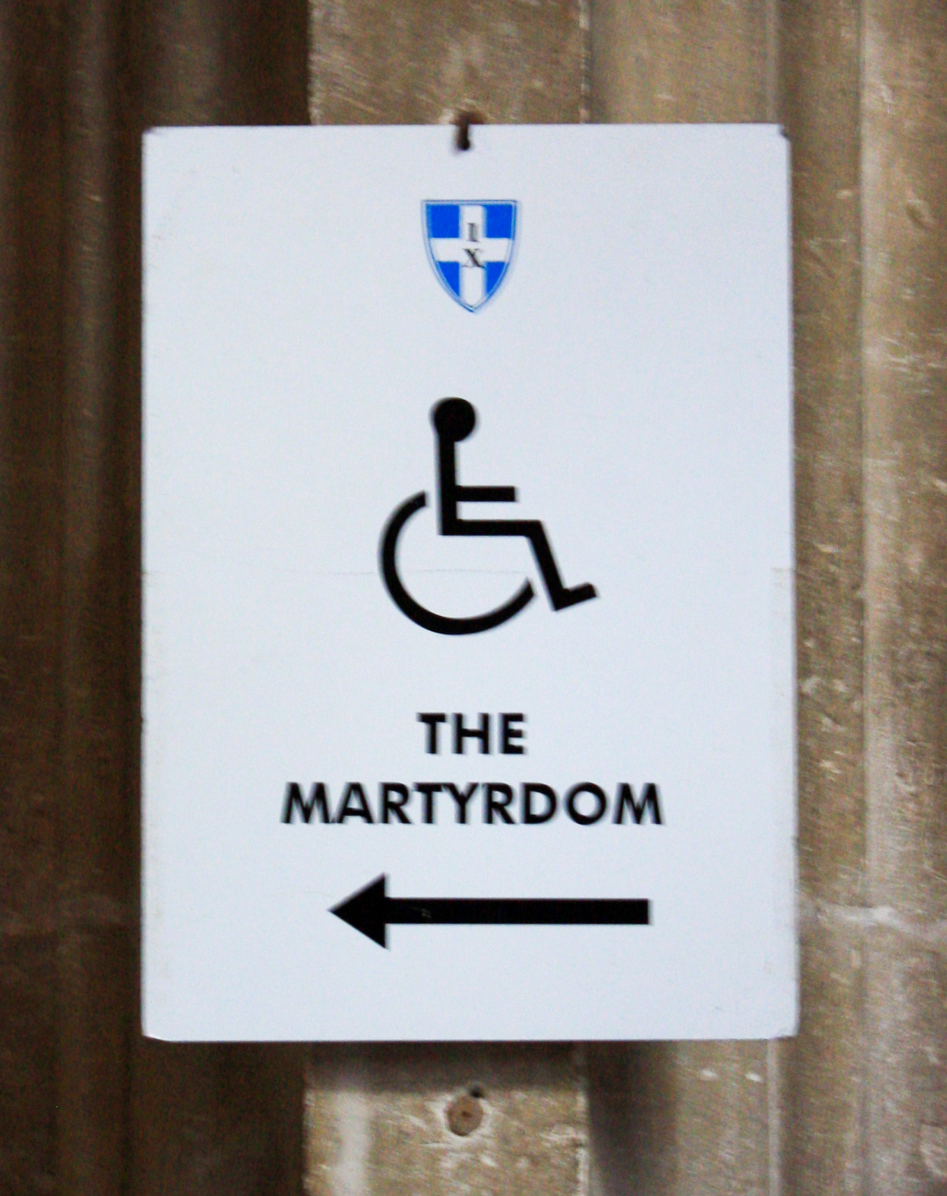 Sign with wheelchair icon in centre and an arrow pointing left to The Martyrdom