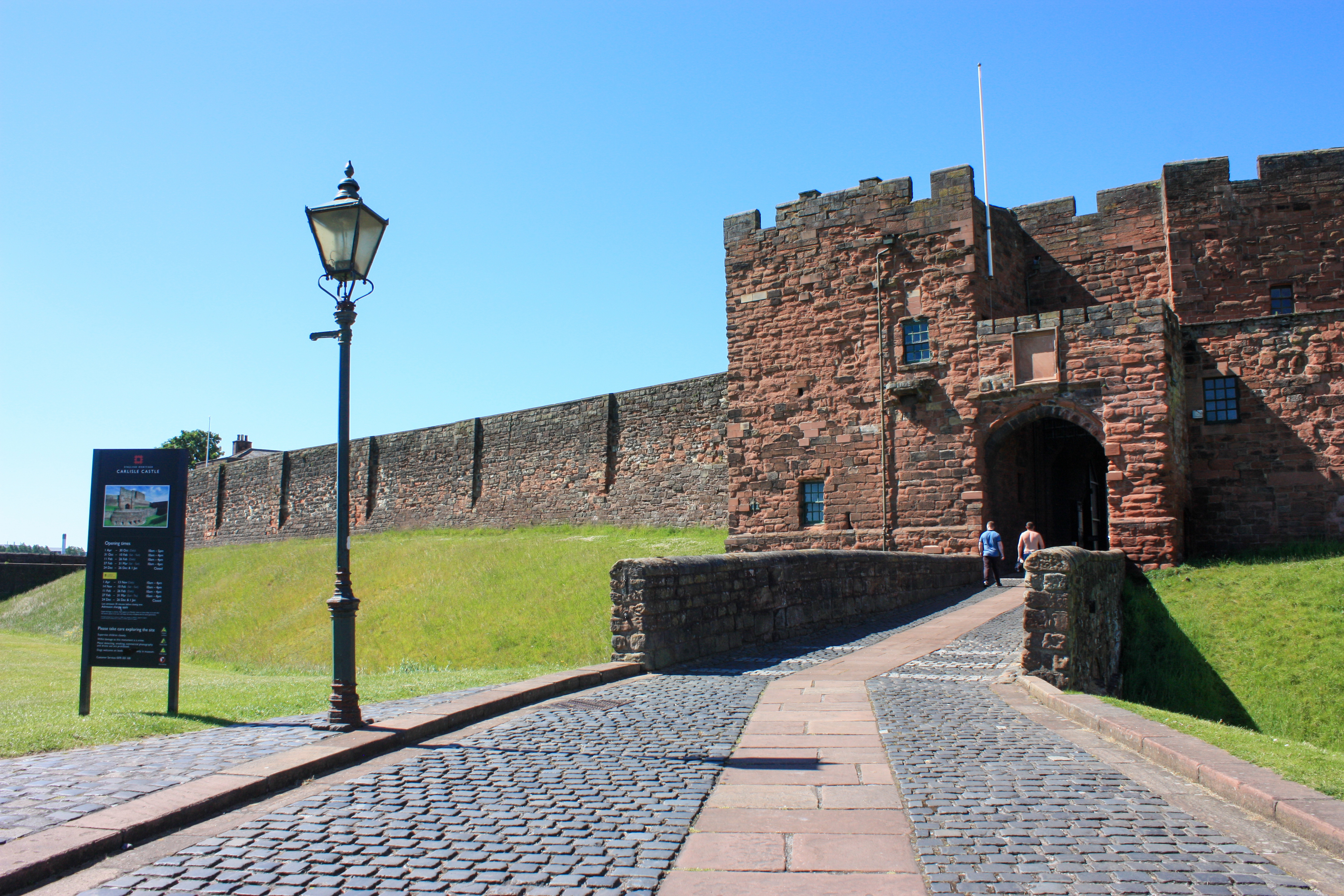 Entrance to castle with cobbled path and an ancient wall with arched gateway