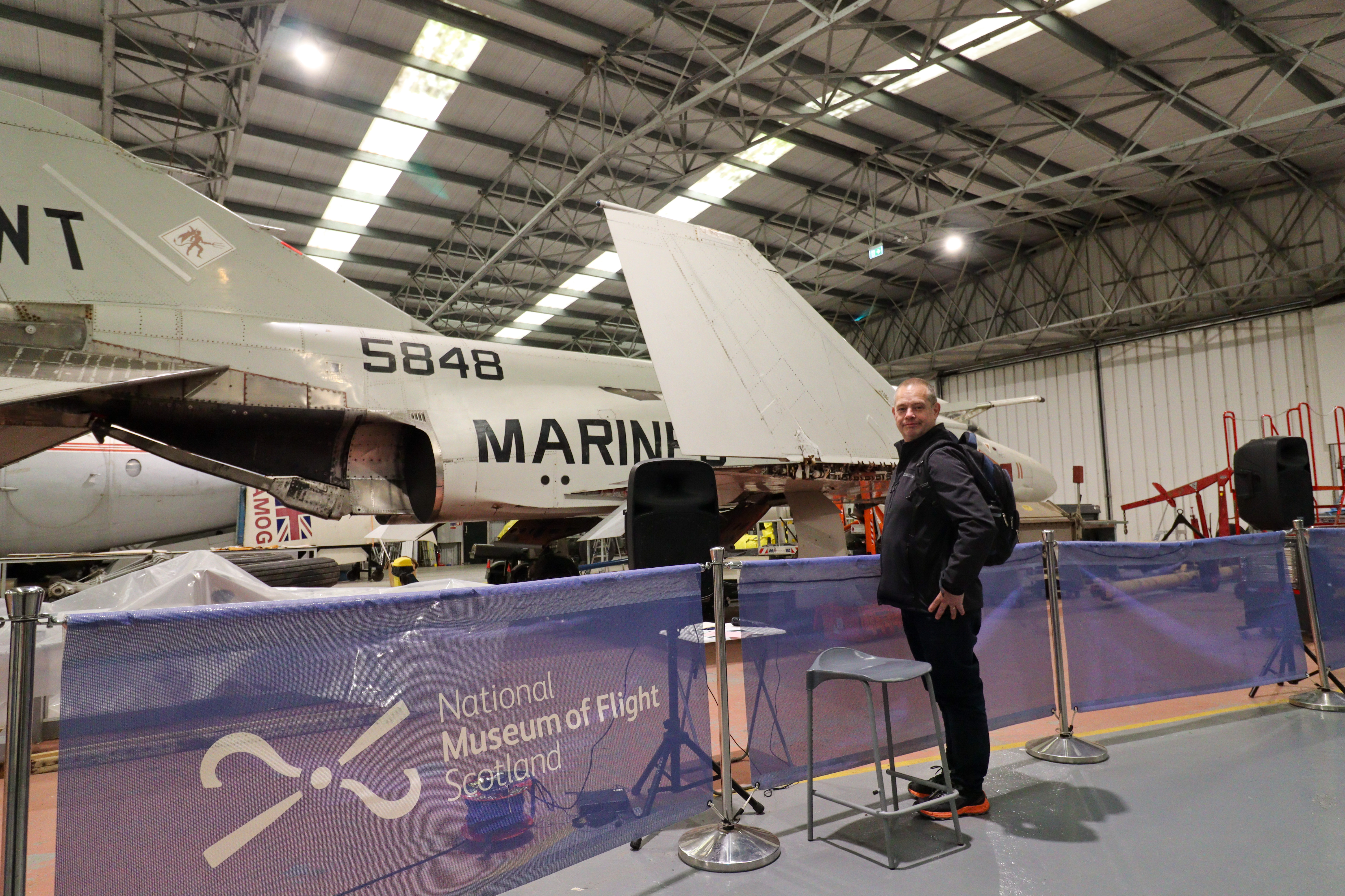 Man looking at a Marina plane with its wing folded up