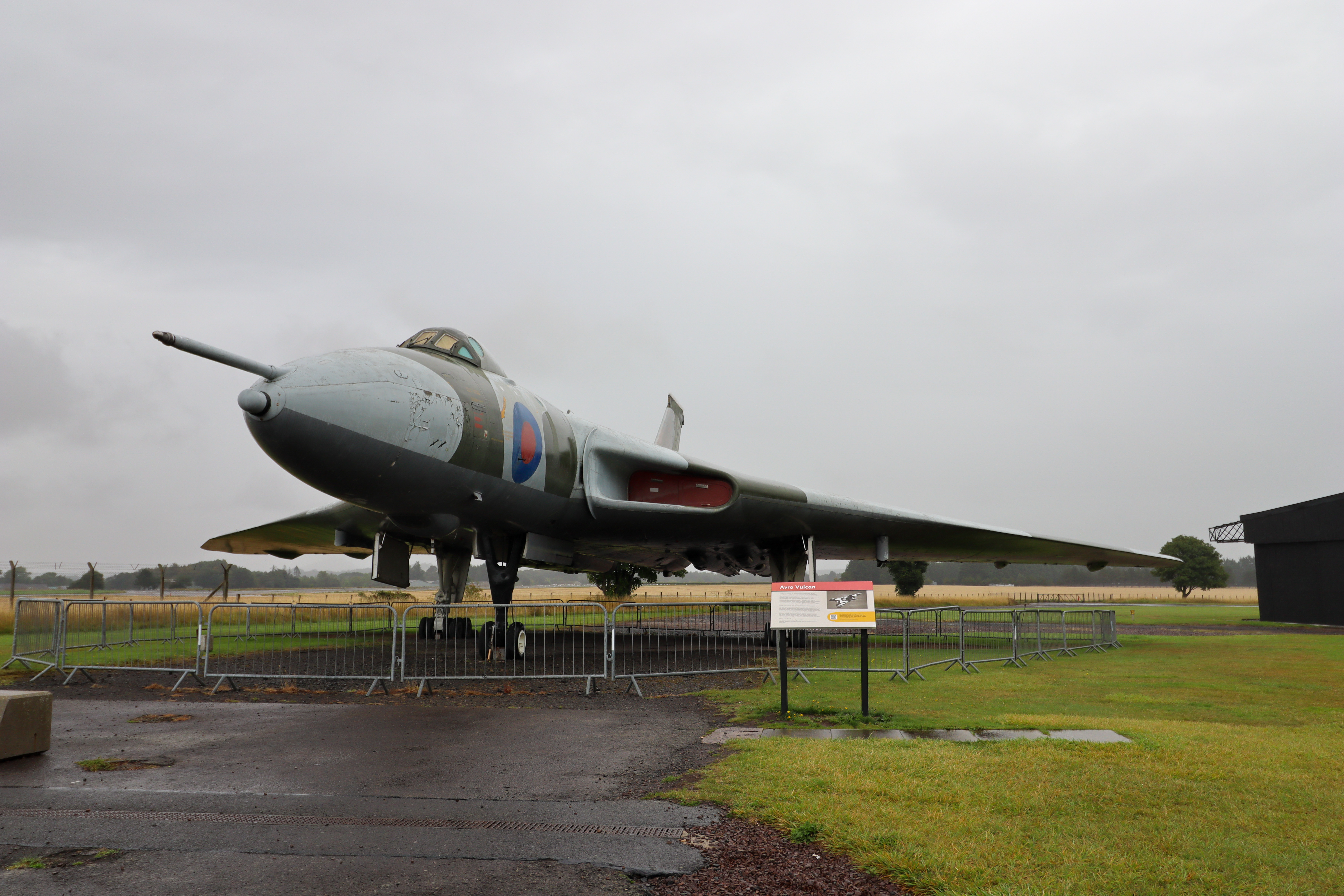 Vulcan plane standing outside on the tarmac with grassy fields surrounding it