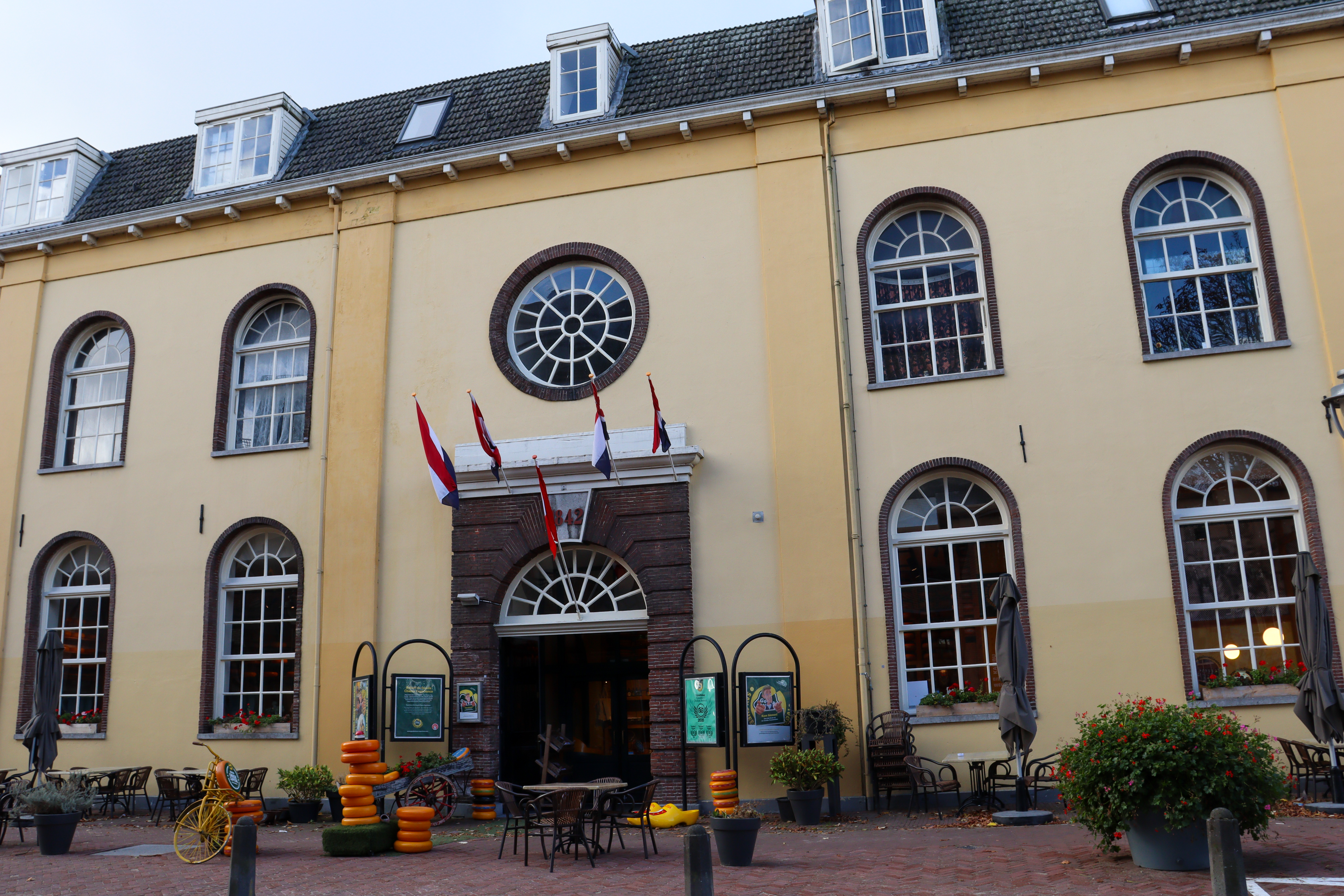 Entrance to the Gouda museum and factory with stacks of Gouda cheese outside