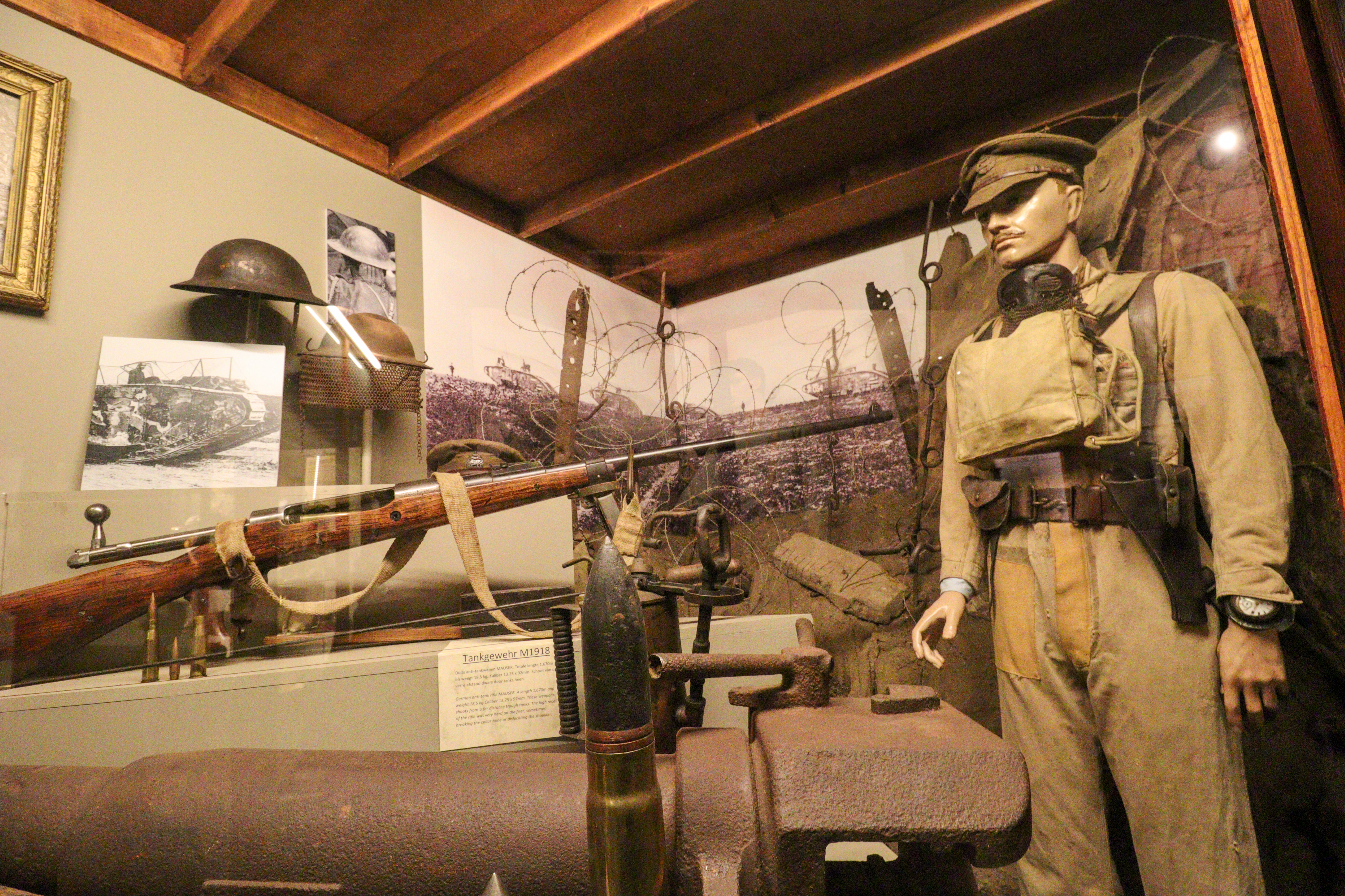 Soldier in beige uniform with a large rifle pointing at him