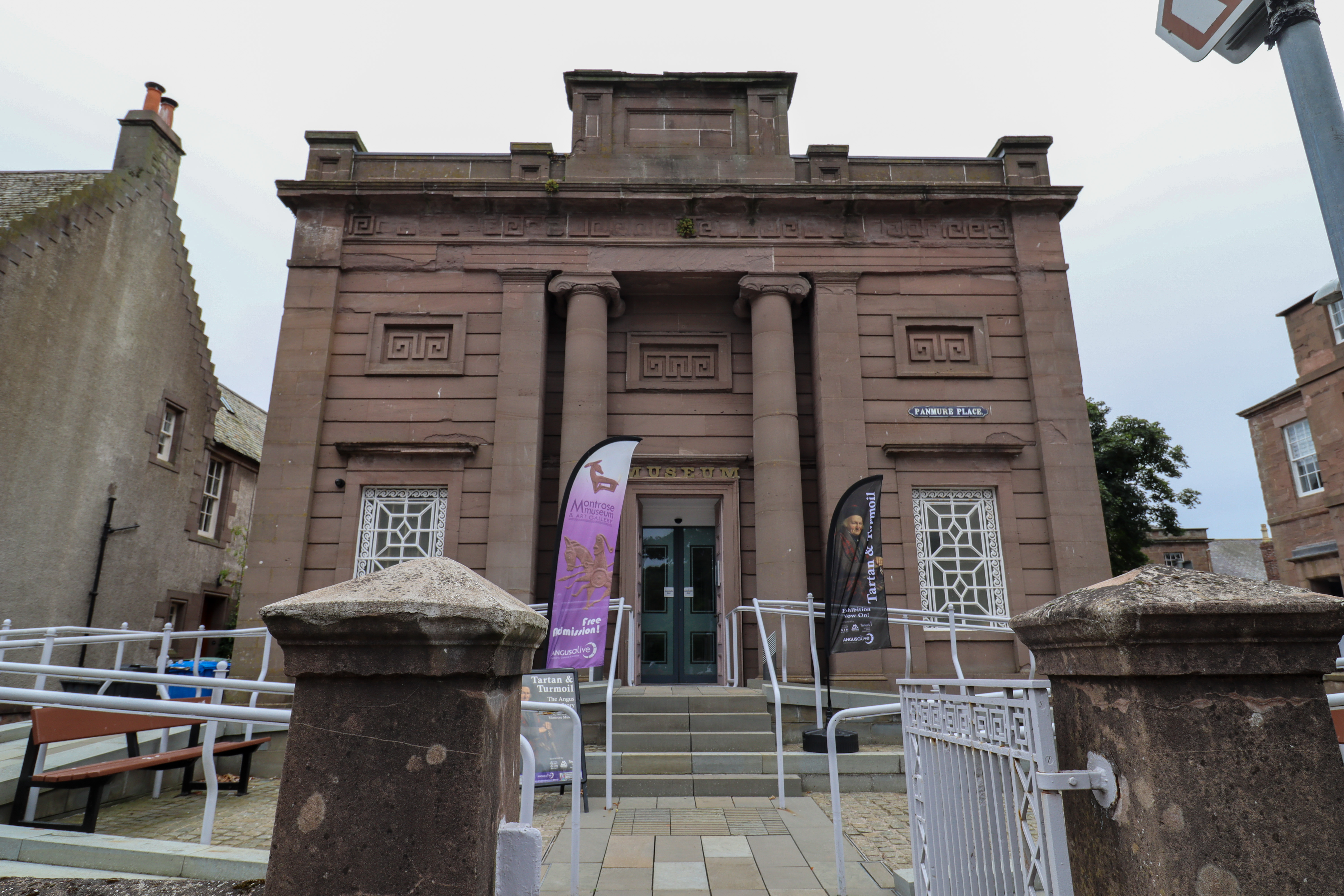 A grand building with stone columns on either side of the entrance