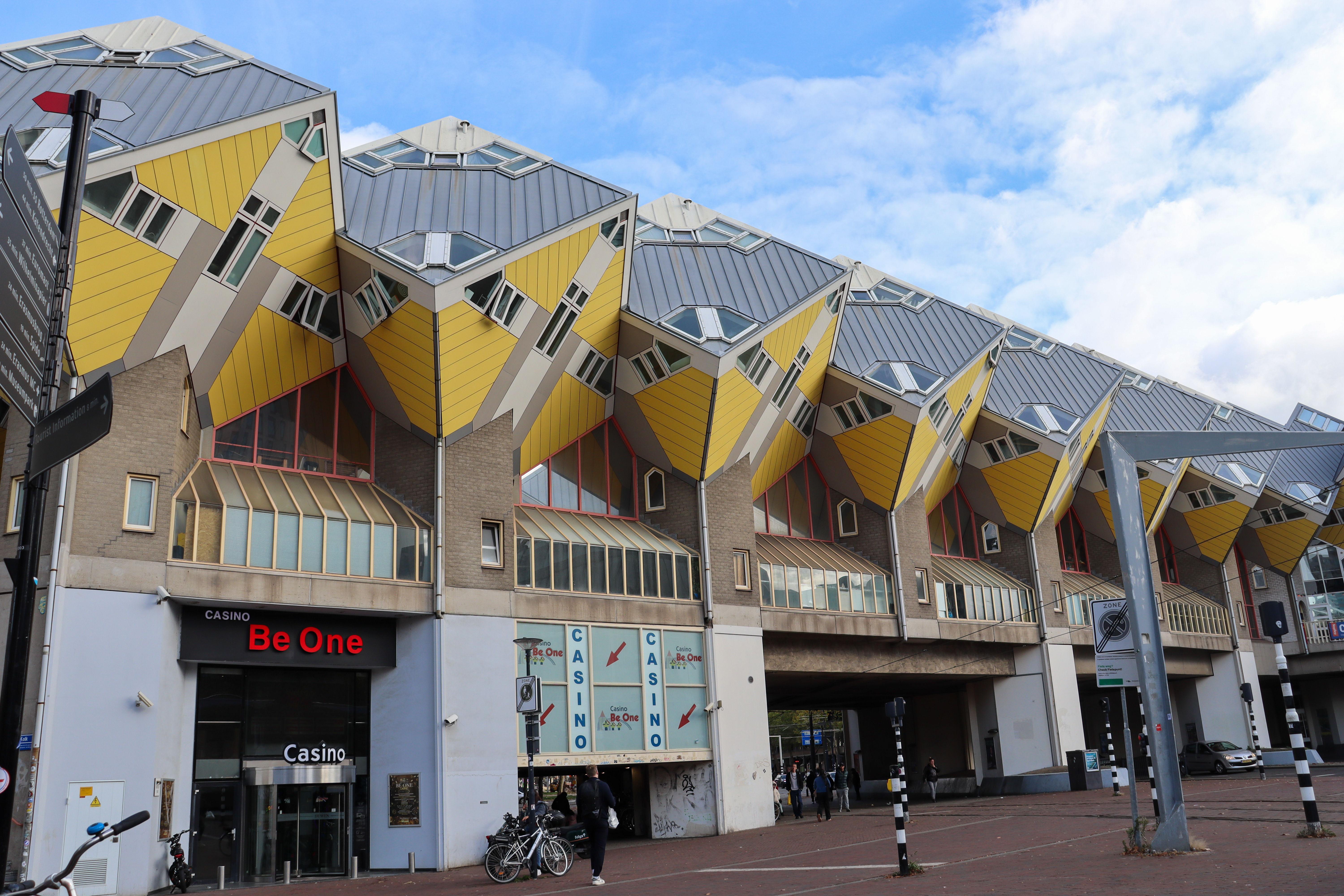 Row of shops with apartments above that are cube shaped and look like they are standing on the point of each cube.