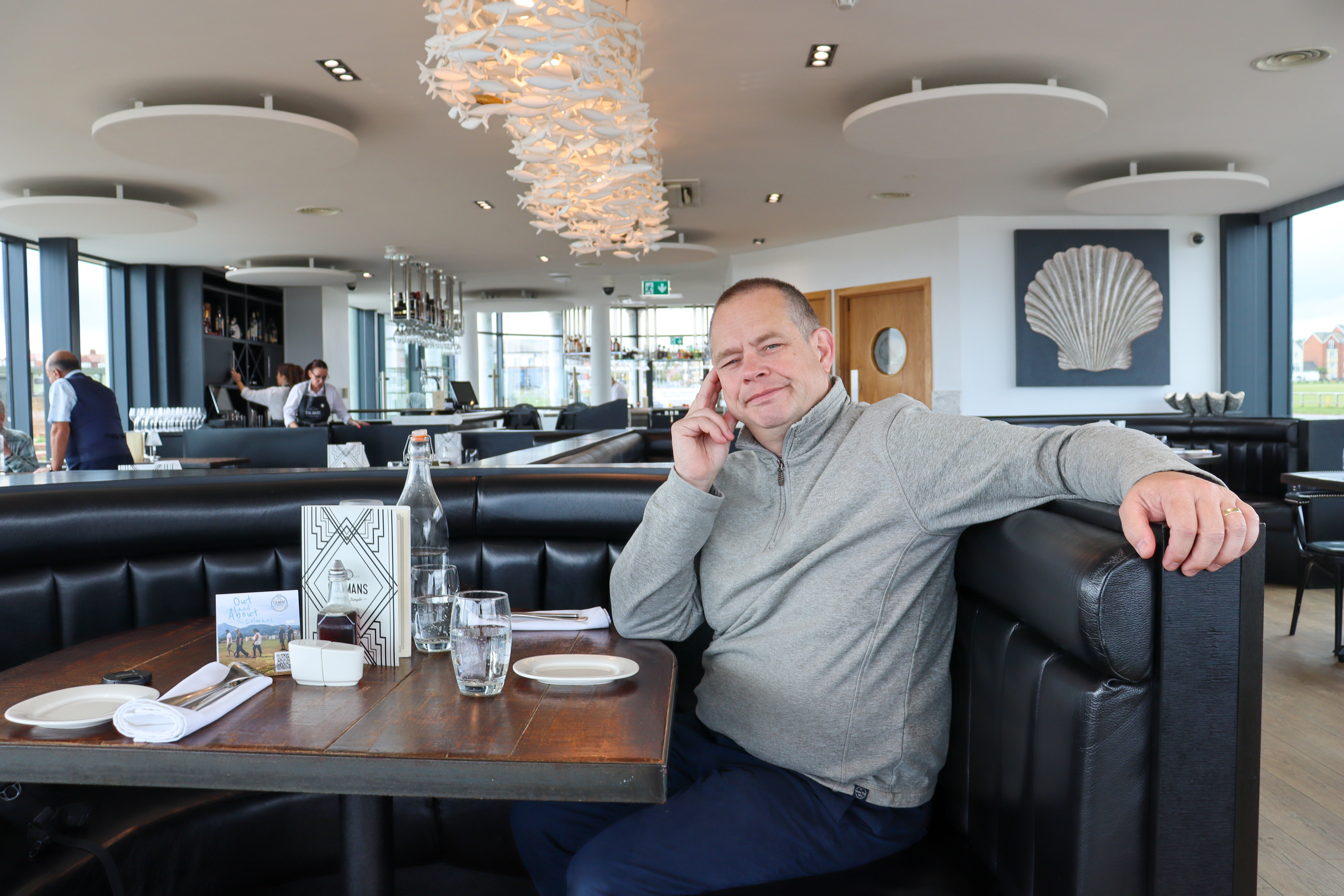 Man sitting at a table in an empty restaurant.