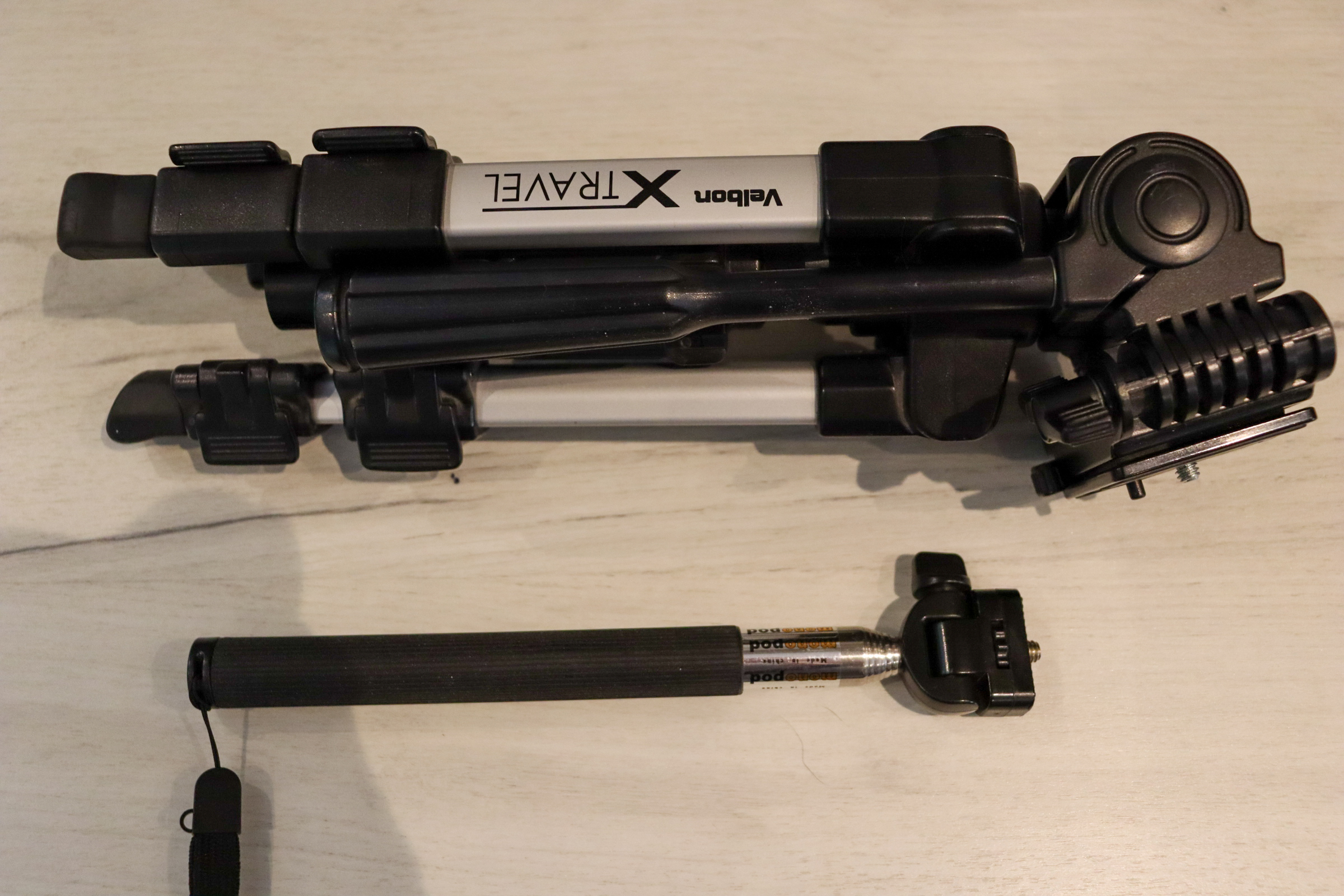 Tripod and monopod lying next to each other, showing that the monopod is much smaller to carry