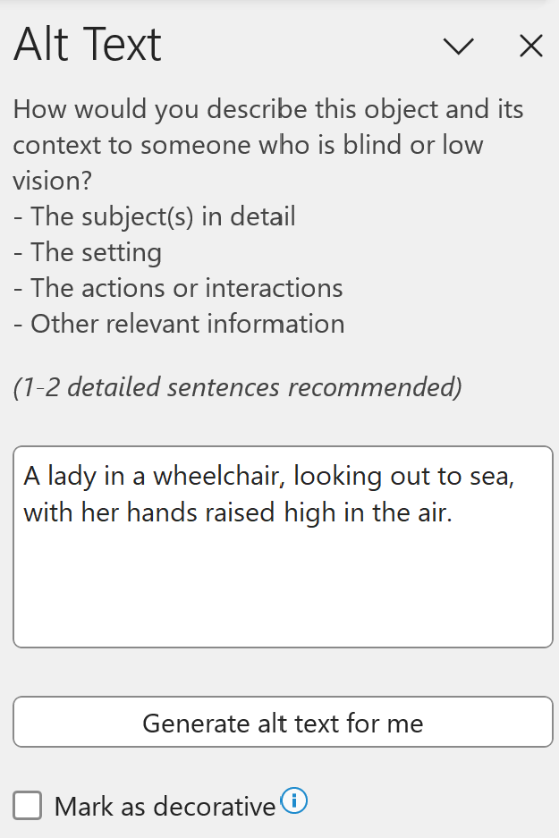 Screenshot of alt text pane with a description: A lady in a wheelchair, looking out to sea, with her hands raised high in the air.